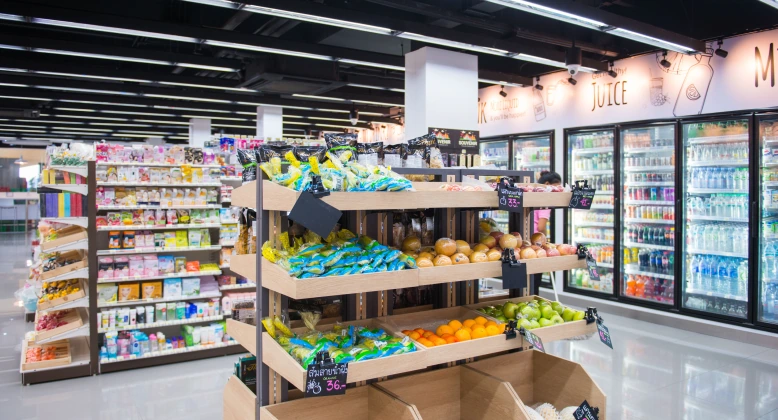 Photo of a convenience store. The produce, snack, and refrigerated aisle are visible.